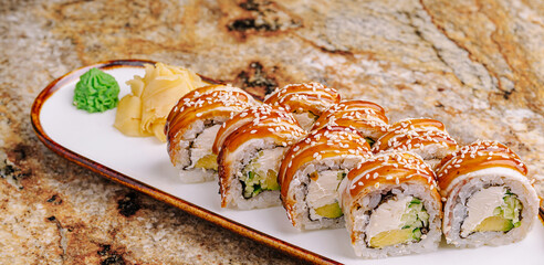 Delicious sushi rolls served on a plate with wasabi and ginger