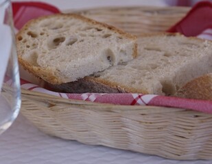Fresh sourdough bread slices in wicker basket