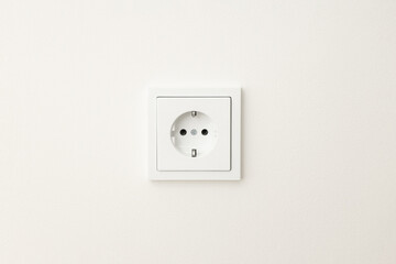 Close up view of a standard electrical outlet on a plain wall