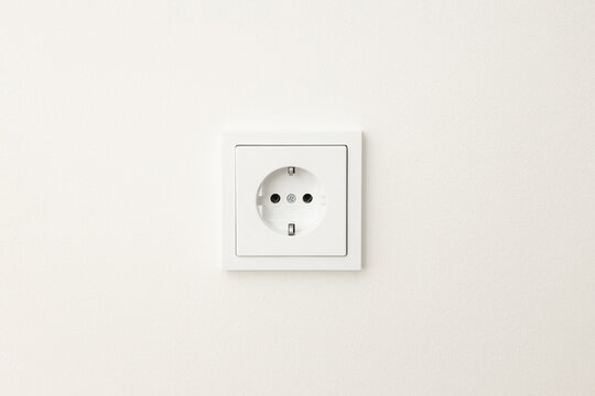 Close up view of a standard electrical outlet on a plain wall