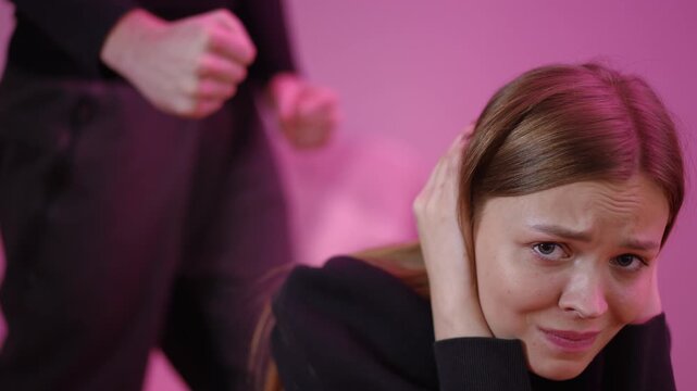 young white office worker cowers under threat as towering figure looms with clenched fists, pink ambient light, fear, hands at ears, defensive posture, domestic