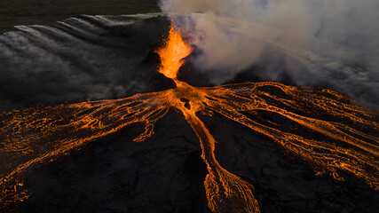 Aerial view of molten lava erupting from the volcano with black cooled lava streams, Reykjanes, Grindavikurber, Iceland.