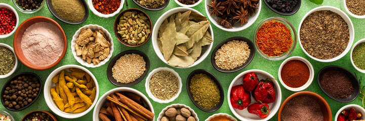 A colorful assortment of fresh, fragrant spices and herbs displayed on a soft green background, capturing a vibrant culinary essence, banner