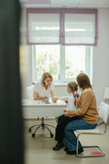 Obraz premium Doctor examining child's hand with mother support