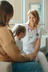 Obraz premium Female doctor consulting with child and mother in clinic