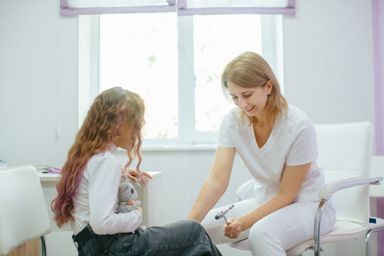 Pediatrician checking child's reflexes at medical visit