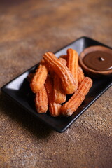 Churros with chocolate dipping sauce in a plate 