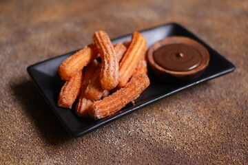 Churros with chocolate dipping sauce on a plate