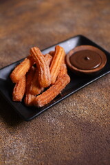 Churros with chocolate dipping sauce in a plate 
