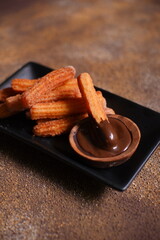 Churros with chocolate dipping sauce in a plate 