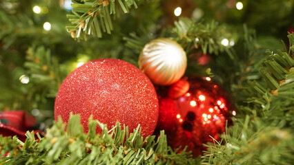Close-up of red Christmas ornament with sparkling lights on decorated tree