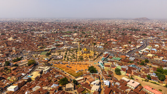 Aerial view of the expansive cityscape featuring a prominent mosque with golden domes amidst a dense urban sprawl, Oko Erin, Kwara, Nigeria.