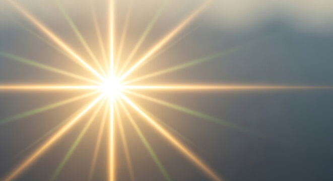 Bright golden starburst light flare effect on soft blue background