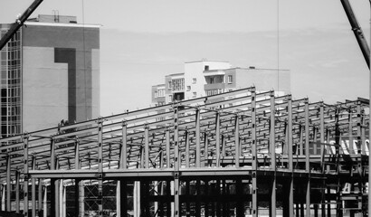 The metal frame of the building under construction. Black and white. Apartment buildings. Grunge urban cityscape. Ust-Kamenogorsk (kazakhstan)