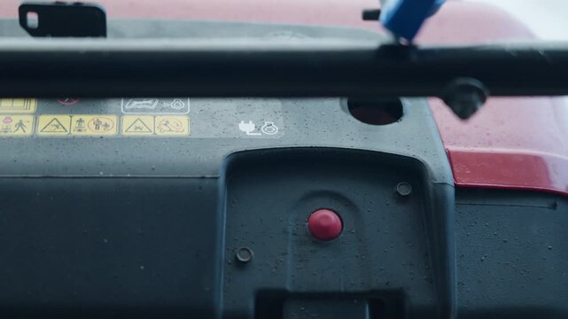 Close-up of snow blower starting button, focus on safety and operation