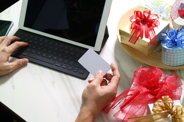Online shopping with gift boxes and credit card in hand