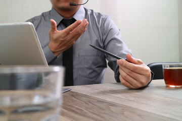 Business professional talking with headset during online meeting