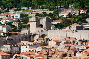 Fototapeta premium High angle view of Minceta Tower and the Dubrovnik city walls. Red roofs of the Old Town in the foreground with the hillside city in the background.