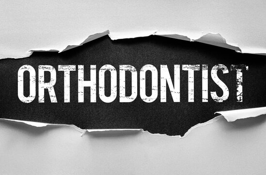 Word ORTHODONTIST displayed under torn paper in bold, distressed typography. Conceptual image for teeth alignment, braces treatment, dental care, jaw correction, and orthodontic expertise