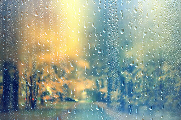 Wet glass, rainy weather, autumn background, rain in the park, blurred abstract backdrop