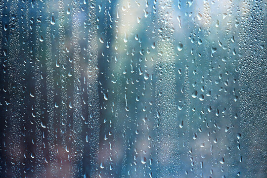 Wet weather, drops of autumn rain on the glass, autumn landscape outside the window, weather change
