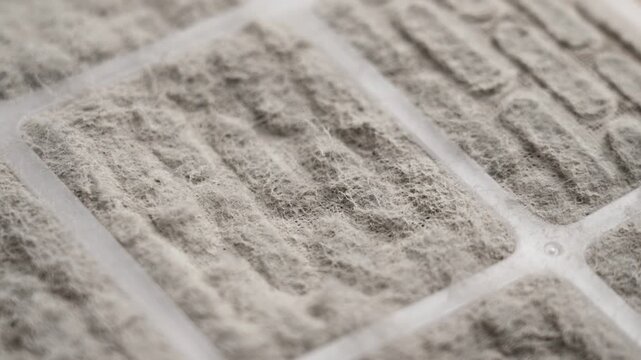 Dusty surface of a clogged dirty industrial ventilation and air conditioning filter close up