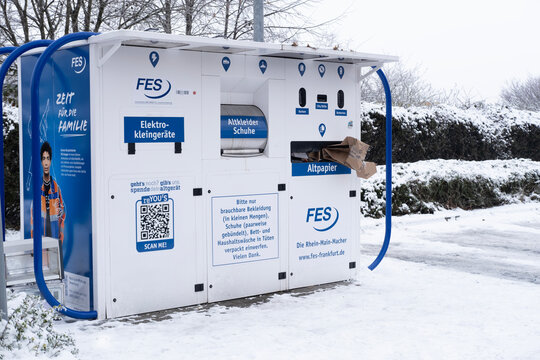 Outdoor recycling station in Germany, for clothes, electronics, and paper, set against winter landscape, modern German municipal waste management, environmental sustainability, various recyclables