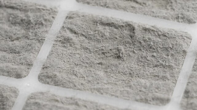 Macro shot of a dusty dirty air filter with plastic frames