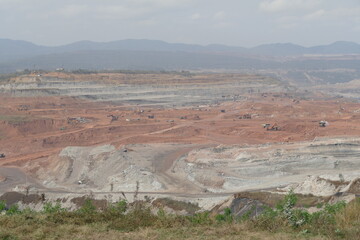 Coal mining in an open pit. Landscape with mountains and trees.