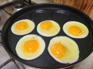 Sunny-Side Up Eggs Cooking in Round Mold Pan