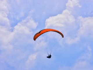 THE BEAUTY OF MOUNT GAJAH TELOMOYO PARALAGLIDING ATHLETES FLYING IN A SEA OF CLOUDS AND A BLUE SKY