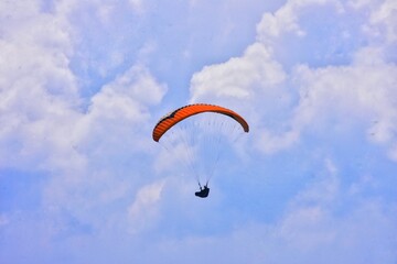 THE BEAUTY OF MOUNT GAJAH TELOMOYO PARALAGLIDING ATHLETES FLYING IN A SEA OF CLOUDS AND A BLUE SKY
