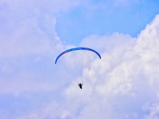 THE BEAUTY OF MOUNT GAJAH TELOMOYO PARALAGLIDING ATHLETES FLYING IN A SEA OF CLOUDS AND A BLUE SKY