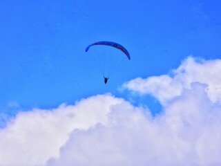 THE BEAUTY OF MOUNT GAJAH TELOMOYO PARALAGLIDING ATHLETES FLYING IN A SEA OF CLOUDS AND A BLUE SKY