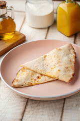 Fresh warm flatbread served folded on a rustic plate with soft natural tabletop background