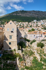 Dubrovnik cityscape showing authentic life with laundry hanging to dry. Ruins in the foreground contrast with the hillside city. Famous Adriatic destination.