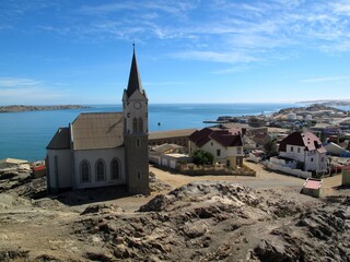 Historic view of Lüderitz, Namibia with colonial architecture and rocky desert shoreline.