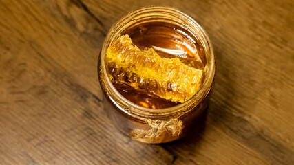  jar of honey with honeycomb on rustic wooden table