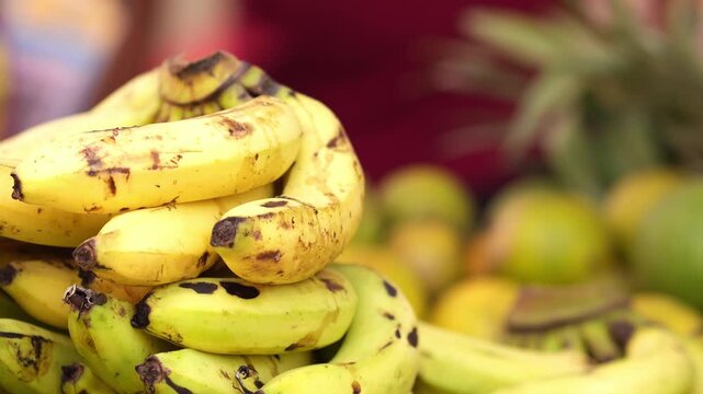 Selective-focus close-up shot of fresh local fruits and bananas stacked together, captured in natural light. 