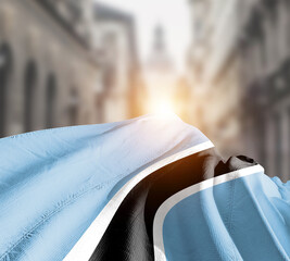 Botswana flag fluttering on blur street with building. Botswana national flag for independence day.