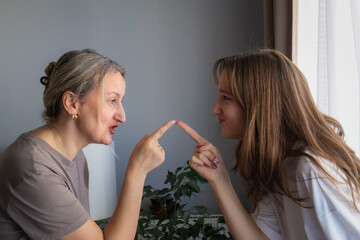 Mother and teenage daughter shouting at each other during intense domestic argument. Authentic...