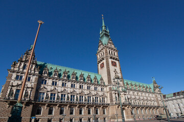 Obraz premium Hamburg City Hall in Germany, a grand Neo-Renaissance building with its prominent tower and intricate facade under a clear blue sky
