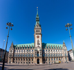 Obraz premium Hamburg City Hall in Germany, a grand Neo-Renaissance building with its prominent tower and intricate facade under a clear blue sky