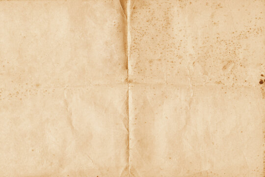 Old Vintage Paper with Folds and Stains Background. Old retro paper folded in four. Brown crumpled and folded parchment vintage paper sheet with space for text