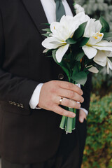 Groom holding wedding bouquet closeup