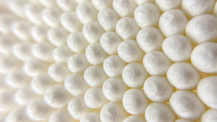 An abstract image of white cotton swabs used for grooming, cleaning, and beauty treatments. Delicate texture and soft lighting.