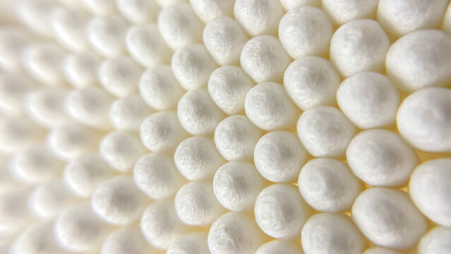 An abstract image of white cotton swabs used for grooming, cleaning, and beauty treatments. Delicate texture and soft lighting.