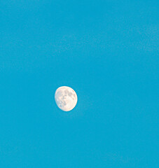 Magical, luminous moon floating quietly above a serene, deep  sky