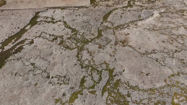 Weathered Concrete With Moss And Branching Patterns Along Cracks Near Wall Of Pensacola Dam In Disney, Oklahoma. drone tilt-up shot