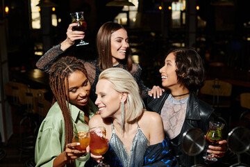 Cheerful friends enjoying a joyful party atmosphere with drinks and laughter at night